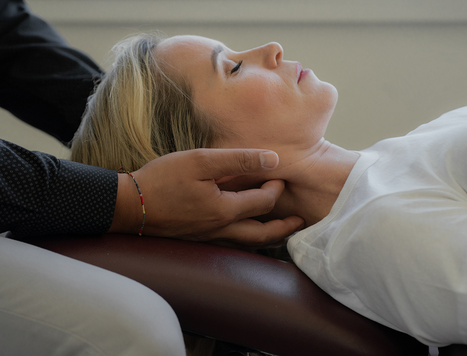Woman on a treatment table receiving chiropractic neck treatment