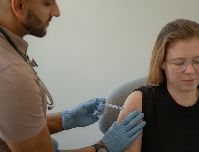Dr. Navdeep Dhindsa giving an injection to a woman